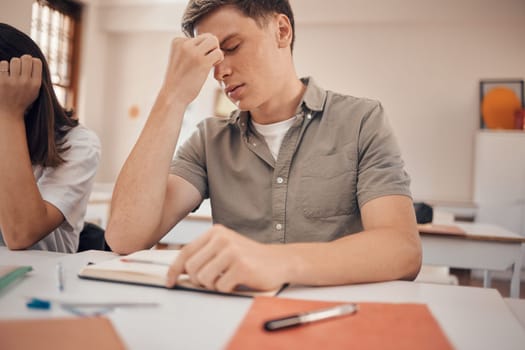 Stress, headache and student in classroom with anxiety, mental health risk and burnout for study, education and learning problem. Tired, fatigue and depression of teenager in school or college desk.
