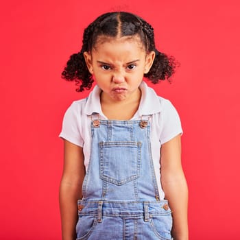 Child, portrait or angry face on isolated red background in emoji tantrum, behavior or stubborn studio problem. Mad, annoyed or frustrated little girl and sulking, grumpy or anger facial expression.