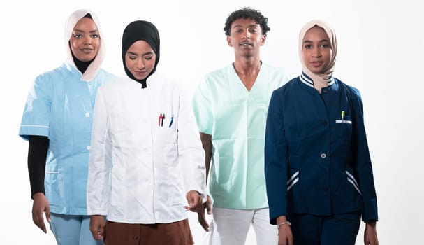 Closeup front view of group of mixed age doctors and nurses standing side by side and looking at the camera. Young Middle Eastern female in a team with African American black doctor. High quality photo