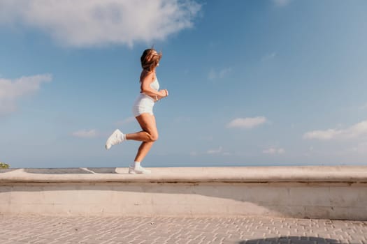 Fitness woman sea. Outdoor workout on yoga mat in park near to ocean beach. Female fitness pilates yoga routine concept. Healthy lifestyle. Happy fit woman exercising with rubber band in park.