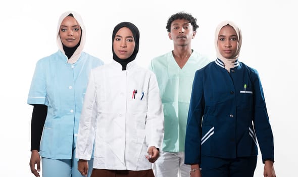 Closeup front view of group of mixed age doctors and nurses standing side by side and looking at the camera. Young Middle Eastern female in a team with African American black doctor. High quality photo