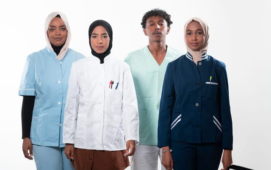 Closeup front view of group of mixed age doctors and nurses standing side by side and looking at the camera. Young Middle Eastern female in a team with African American black doctor. High quality photo