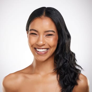 Beauty, hair and portrait of happy woman in studio for cosmetics, treatment and shine on grey background. Smile, face and haircare for female model excited with volume, texture and keratin results.