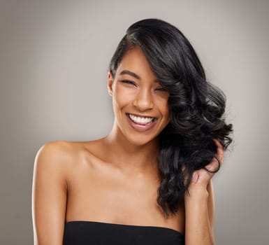 Haircare, beauty and portrait of happy woman in studio for cosmetics, treatment and shine on grey background. Hair, face and satisfied female model posing with volume, texture and keratin results.