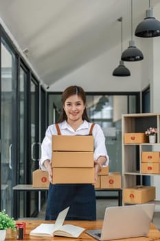 Woman startup small business entrepreneur works with boxes in a her workplace. Ecommerce business idea.