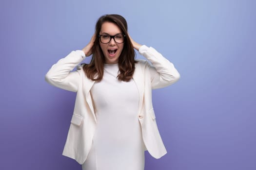 smart woman with thick dark hair in white outfit on studio background.