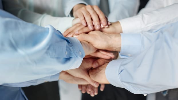 Top view shot of stack of hands. Young college students putting their hands on top of each other symbolizing unity and teamwork.