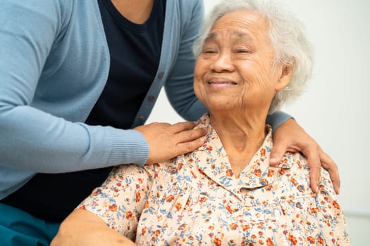 Caregiver help Asian elderly woman patient with love, care, encourage and empathy at nursing hospital, healthy strong medical concept.