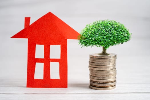 House model with growing plant on stack of coin money, home loan, saving plan, installment payment finance and banking concept.