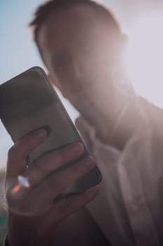 A businessman using his smartphone outdoors, showcasing the seamless integration of technology and mobility in modern professional life