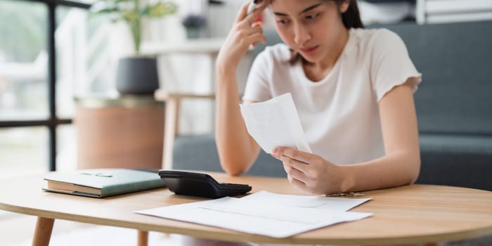 Asian accounting professional calculating household bills, reviewing and analyzing household bills, and filing tax returns.