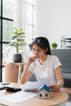 Asian accounting professional calculating household bills, reviewing and analyzing household bills, and filing tax returns.