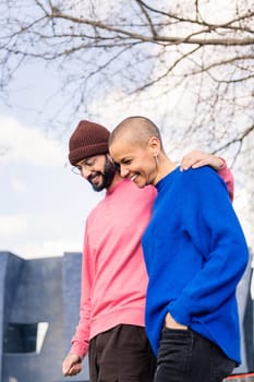 young couple of man and woman smiling happy during a romantic walk in a city park, concept of love and modern lifestyle