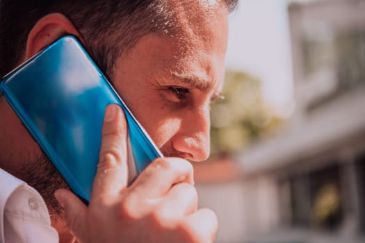 A businessman using his smartphone outdoors, showcasing the seamless integration of technology and mobility in modern professional life