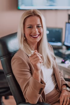 A businesswoman sitting in a programmer's office surrounded by computers, showing her expertise and dedication to technology