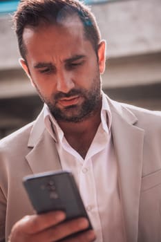 A businessman using his smartphone outdoors, showcasing the seamless integration of technology and mobility in modern professional life