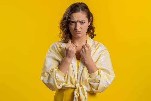 Offended sad nervous woman having misunderstanding, frustrated after quarrel, fail, lose, ignores and does not want to communicate, talk. Girl isolated on yellow studio background. People lifestyle