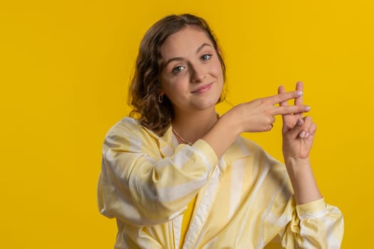 Hashtag. Woman showing hashtag symbol with fingers hands, likes tagged message, popular viral social media content, sign to follow internet online trends. Girl isolated on yellow studio background