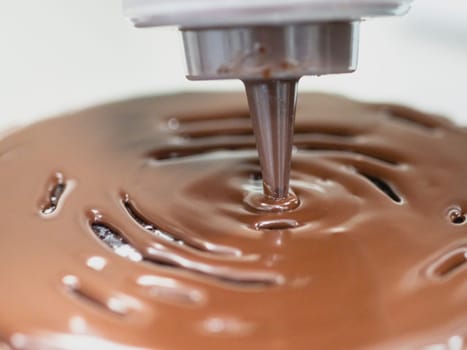 pastry chef preparing a chocolate frosted dripped icing cup cake with sweet fruit topping and golden brush strokes