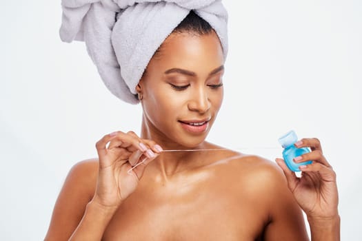 Dental, floss and black woman face, flossing for teeth whitening, healthcare and hygiene isolated on white background. Oral care product, skincare and mouth cleaning for fresh breath in studio shot.