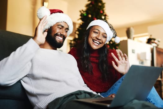 Video call, laptop and Christmas couple on sofa with hello wave for global, international or virtual communication with friends or family. Happy black people on zoom call for holiday celebration chat.