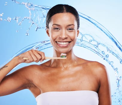 Black woman, toothbrush or smile with water splash for health skincare, wellness or dental teeth in blue studio background. Happy portrait of African girl brushing teeth for beauty or toothpaste.