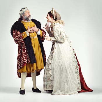 Argue, medieval and king with queen on a white background for argument, anger and frustrated fight. History, theatre and royal couple in vintage, renaissance and history cosplay isolated in studio.