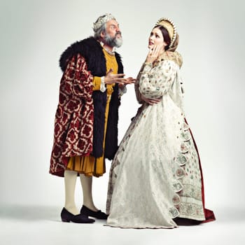 Anger, medieval and king with queen on a white background for argument, frustrated and fighting. History, theatre and royal couple in vintage, renaissance and Victorian cosplay isolated in studio.