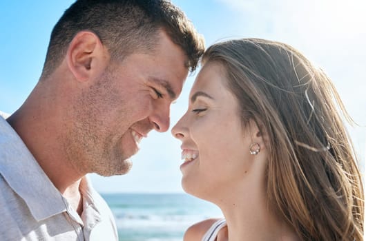 Couple, love and happy smile at beach, holiday and anniversary travel in summer with romance in Ibiza. Young man and woman enjoy marriage, happiness and content together outdoor at a ocean vacation.