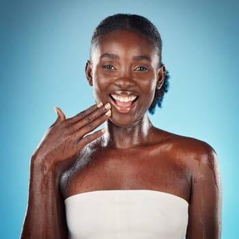 Black woman, skincare beauty and cosmetics wellness touch face for skin happiness. Young African american girl, facial care and smile for luxury skin health lifestyle in blue background studio.
