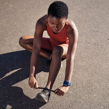 Running, fitness and tie shoes with black woman in road for cardio, workout and training. Sports, ready and performance with girl runner fixing sneakers for jogging, start and stamina endurance.