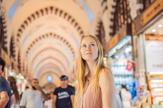 A tourist woman walks among the countless shops at the Grand Bazaar and Egyptian Bazaar in Istanbul. Shopping and travel in Turkey concept. Istanbul historical Egyptian Bazaar. Misir Carsisi, spice market. Turkiye.