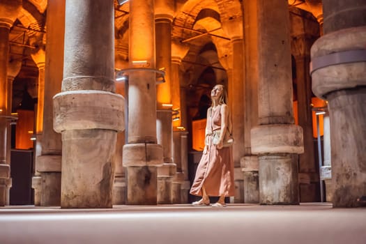 Woman tourist enjoying Beautiful cistern in Istanbul. Cistern - underground water reservoir build in 6th century, Istanbul, Turkey, Turkiye.