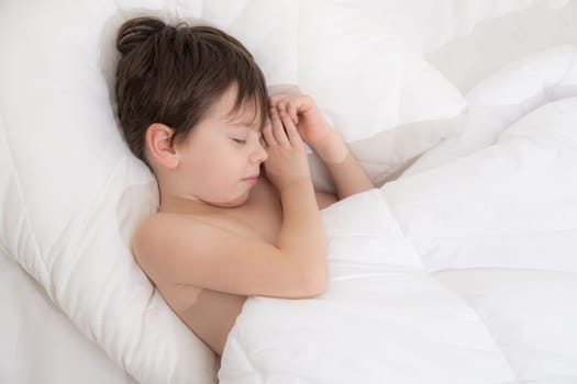 The child is sleeping sweetly in his bed . Sweet baby's dream. The child is in bed . An article about children's dreams. Boy