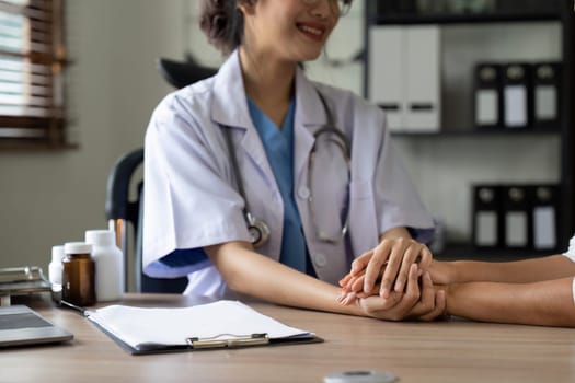 Hand of doctor reassuring her senior female patient. Medical ethics and trust concept.