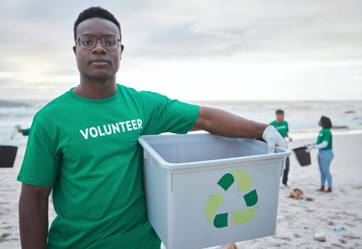 Cleaning, recycling and portrait of black man on beach for sustainability, environment or eco friendly. Climate change, earth day or nature with volunteer and plastic for charity or community service.