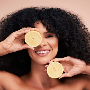 Face portrait, hair care and black woman with lemon in studio isolated on a brown background. Fruit, skincare and happy female model with lemons for healthy diet, nutrition or vitamin c and minerals