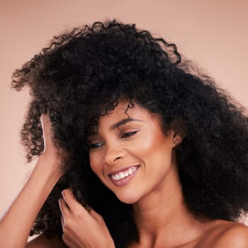 Hair care texture, black woman and cosmetics of young model with a healthy afro from salon treatment. Happy face, cosmetics and African person with wellness, skincare and smile from beauty in studio.