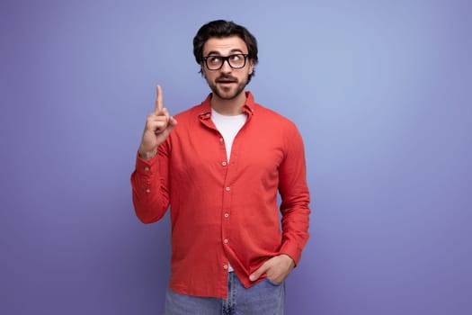 smart handsome young brunette man in glasses and a red shirt on the background with copy space.