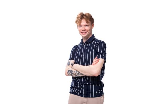 stylish handsome young blond man with tattoos on his arm on a white background.