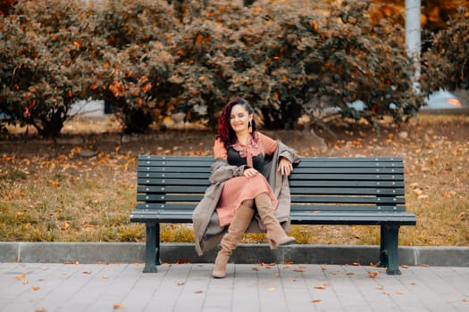 A woman walks outdoors in autumn, enjoys the autumn weather