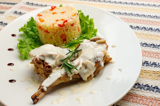 Roasted or fried quail with herbs and rise on a white plate.