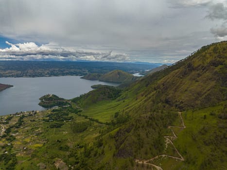 Aerial drone of mountains with forest and Lake Toba. Samosir Island. Sumatra, Indonesia.