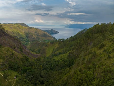 Lake Toba among the mountains with tropical vegetation. Sumatra, Indonesia.