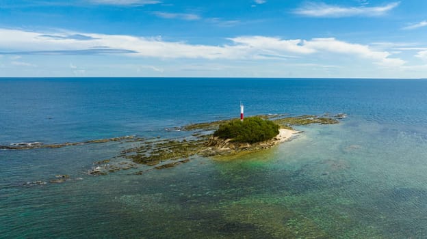 Aerial view of rocky island with a lighthouse in the blue sea. Borneo, Malaysia.