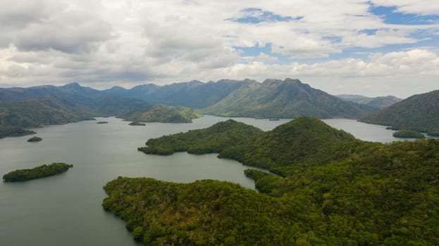 A lake with islands surrounded by mountains with a tropical forest. Randenigala reservoir.