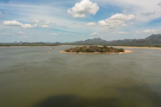 An island and a lake in the jungle in a mountain valley. Kandalama Reservoir in Sri Lanka.