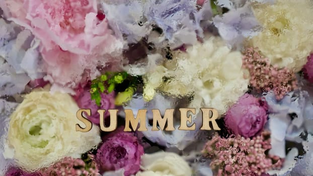 floral flowers background with the inscription summer with water droplets. wooden letters, close-up, top view, abstract