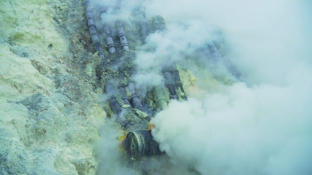 Extraction of sulfur in the crater of a volcano. Sulfur gas, smoke. Kawah Ijen, crater with acidic crater lake where sulfur is mined. Ijen volcano complex is a group of stratovolcanoes in the Banyuwangi Regency of East Java, Indonesia.