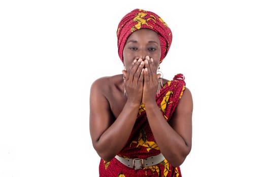 african woman wearing a traditional clothes, looks at the camera hand on surprise mouth isolated on white background